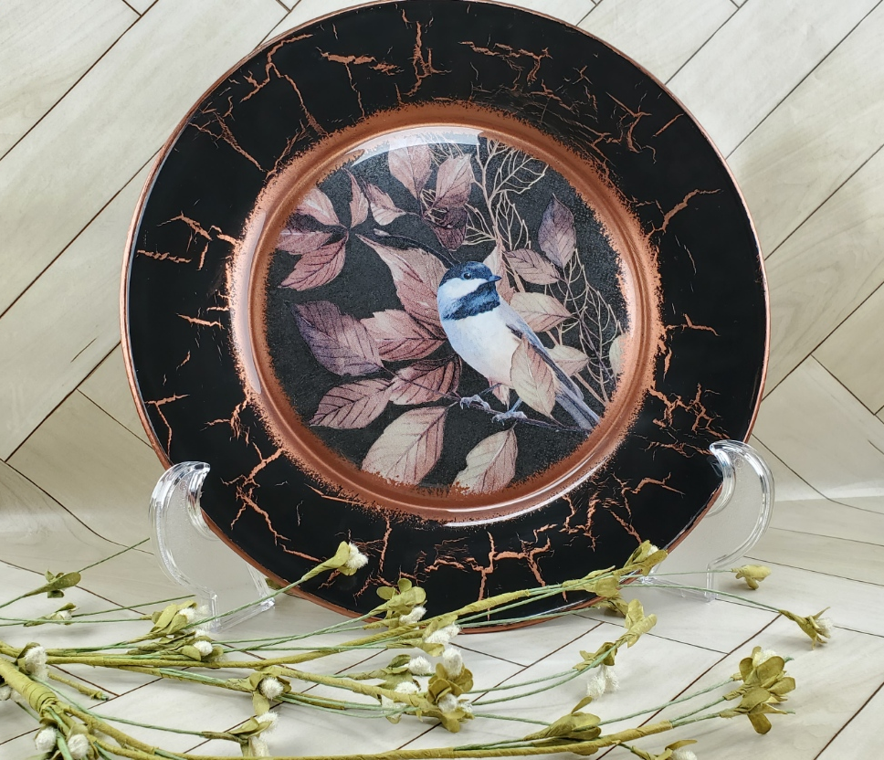 Image of decorative display Plate with a bird in the center and copper gilding.