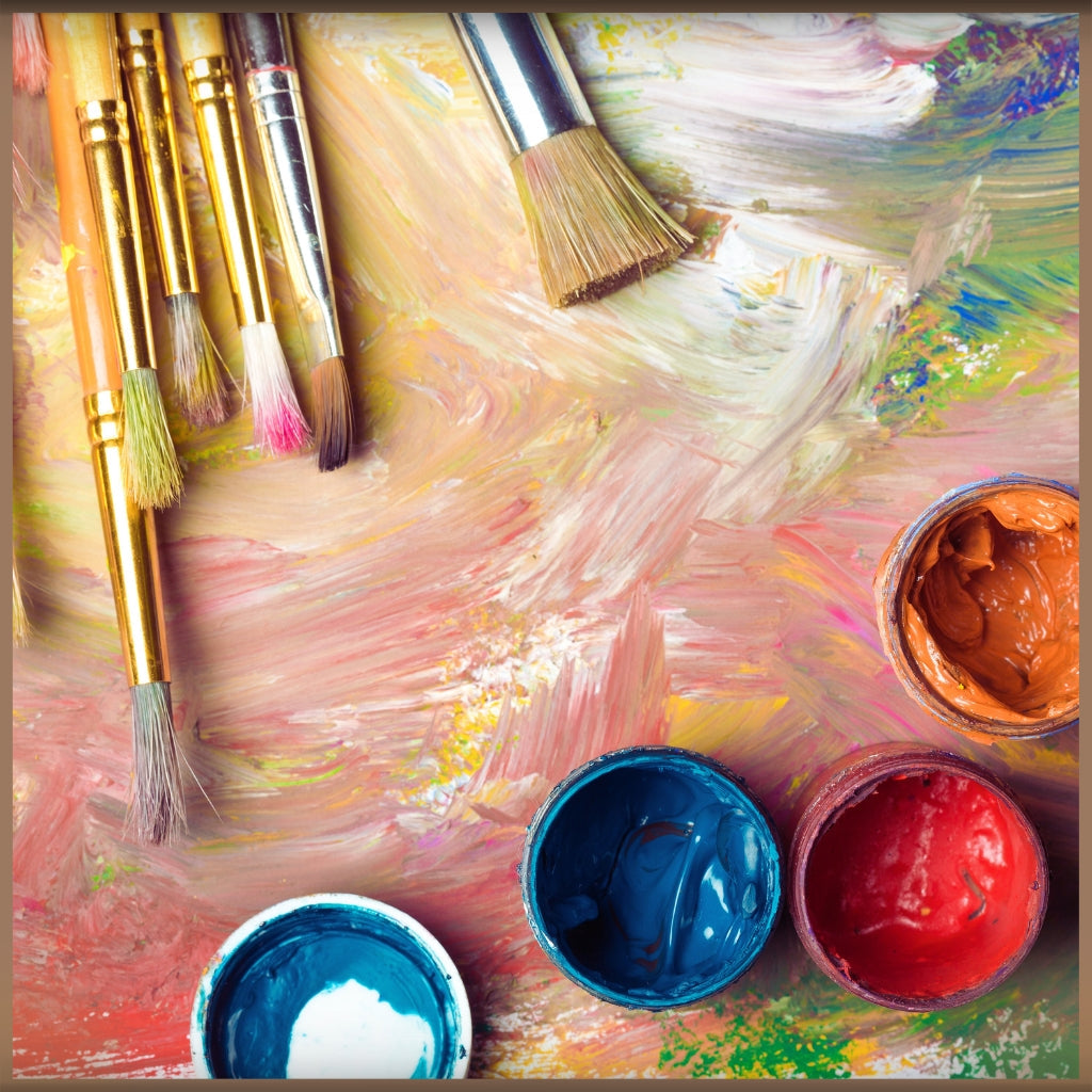 Image of paint brushes on a painted surface with jars of colorful paint