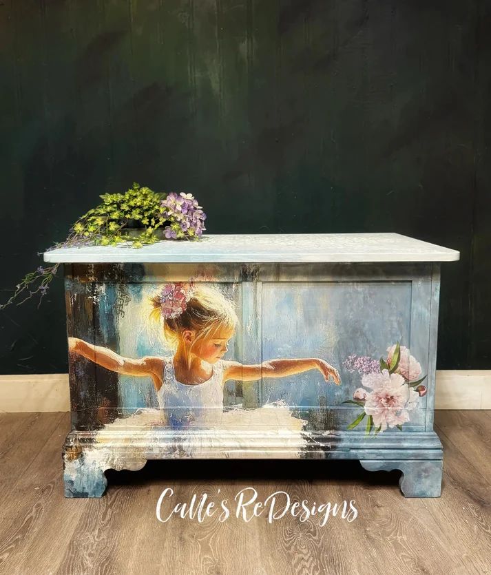 Decorative wooden storage chest with a mural of a girl in a white dress, surrounded by purple flowers, set against a dark green wall